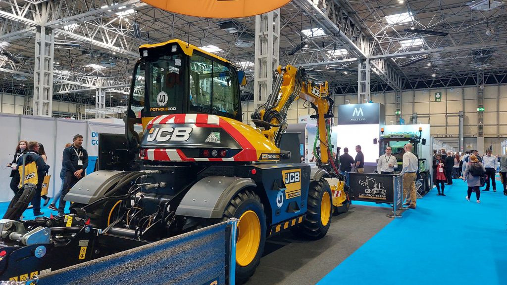 In the centre is a yellow JCB digger  being exhibited at the JCB stand 